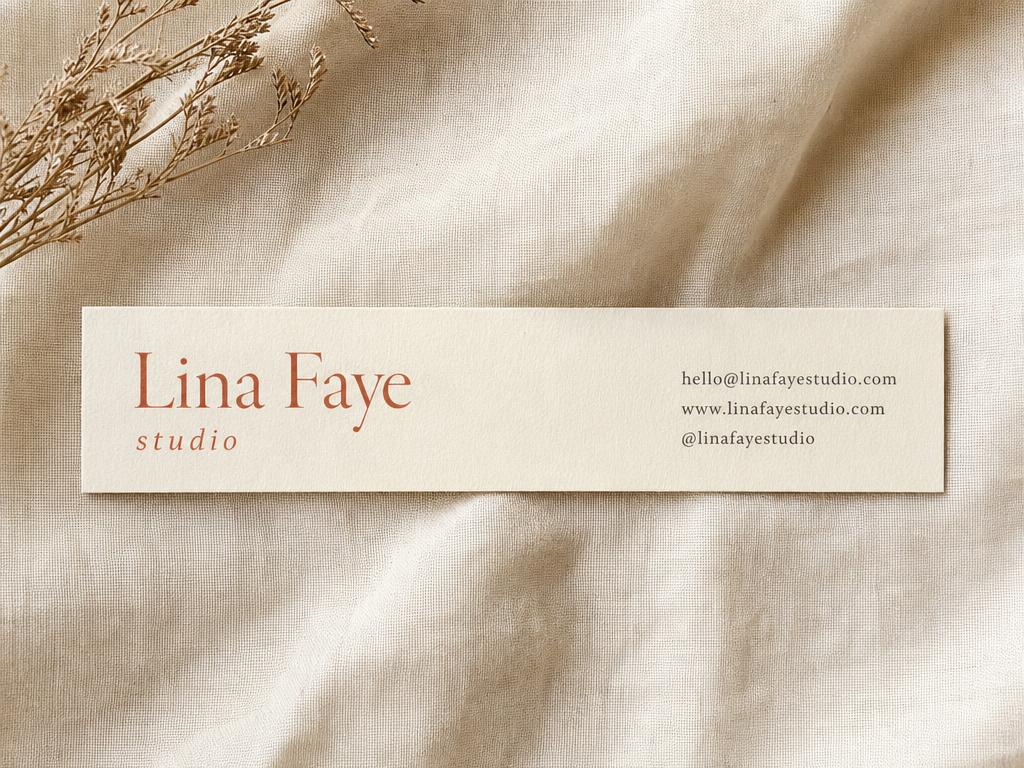 Slim long rectangle business card 90 by 50 mm on cream linen with terracotta serif name