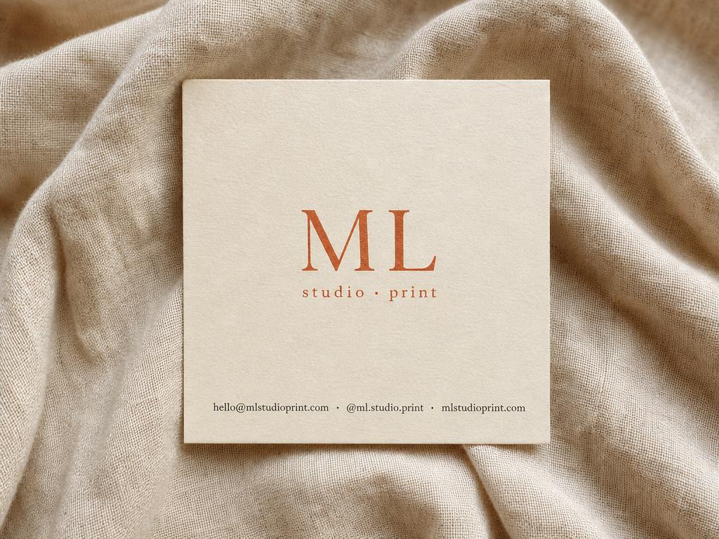 Square business card 55 by 55 mm on cream linen with terracotta ML monogram